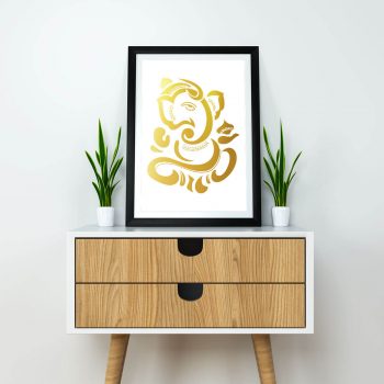 Gold foiled Ganesh wall art on White paper on a cabinet