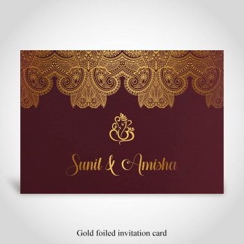 Dark red Hindu wedding card with gold foiled Ganesh and bride and grooms names