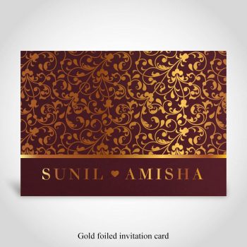 Gold foiled floral pattern on dark red Hindu wedding card