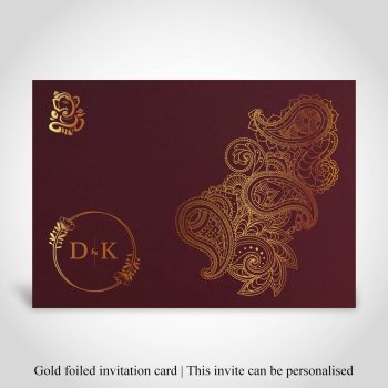 Dark red Hindu wedding invite, ganeshji, paisley design and couples initials all foiled in gold.
